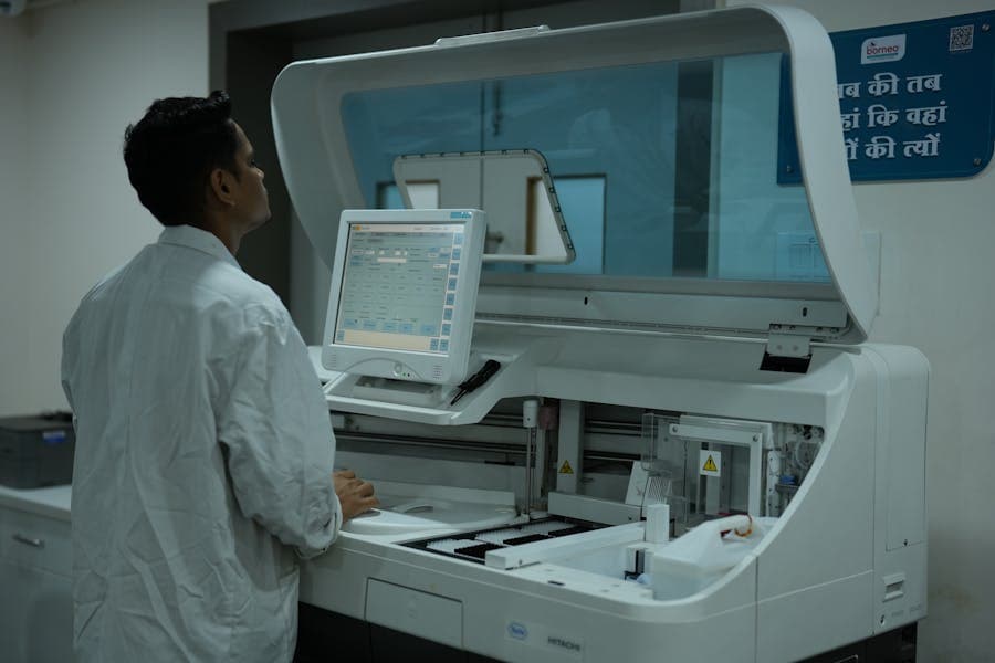 Laboratory technician operating and inspecting clinical medical equipment